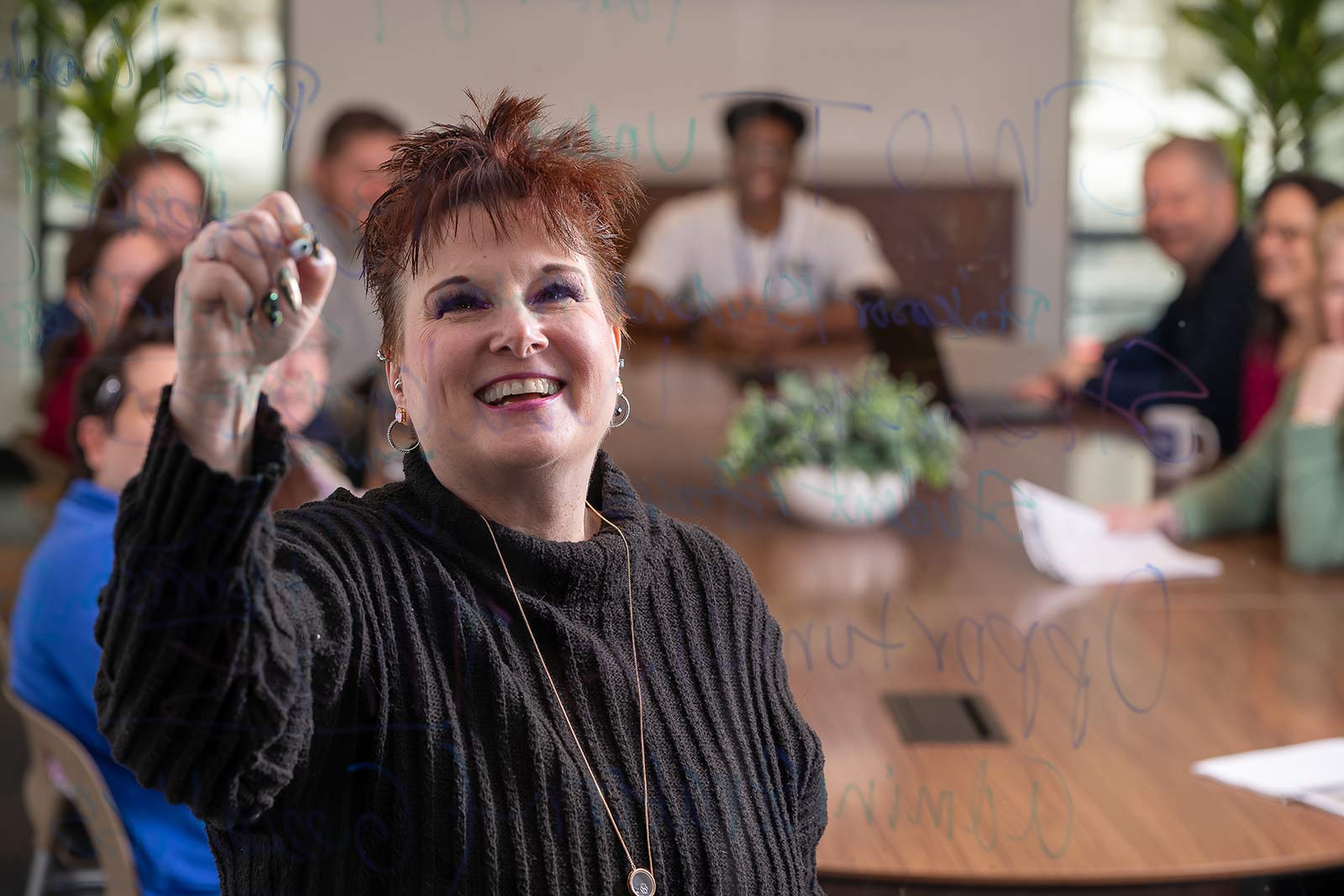 Professor Melissa Hopper-Ford writing notes for the class