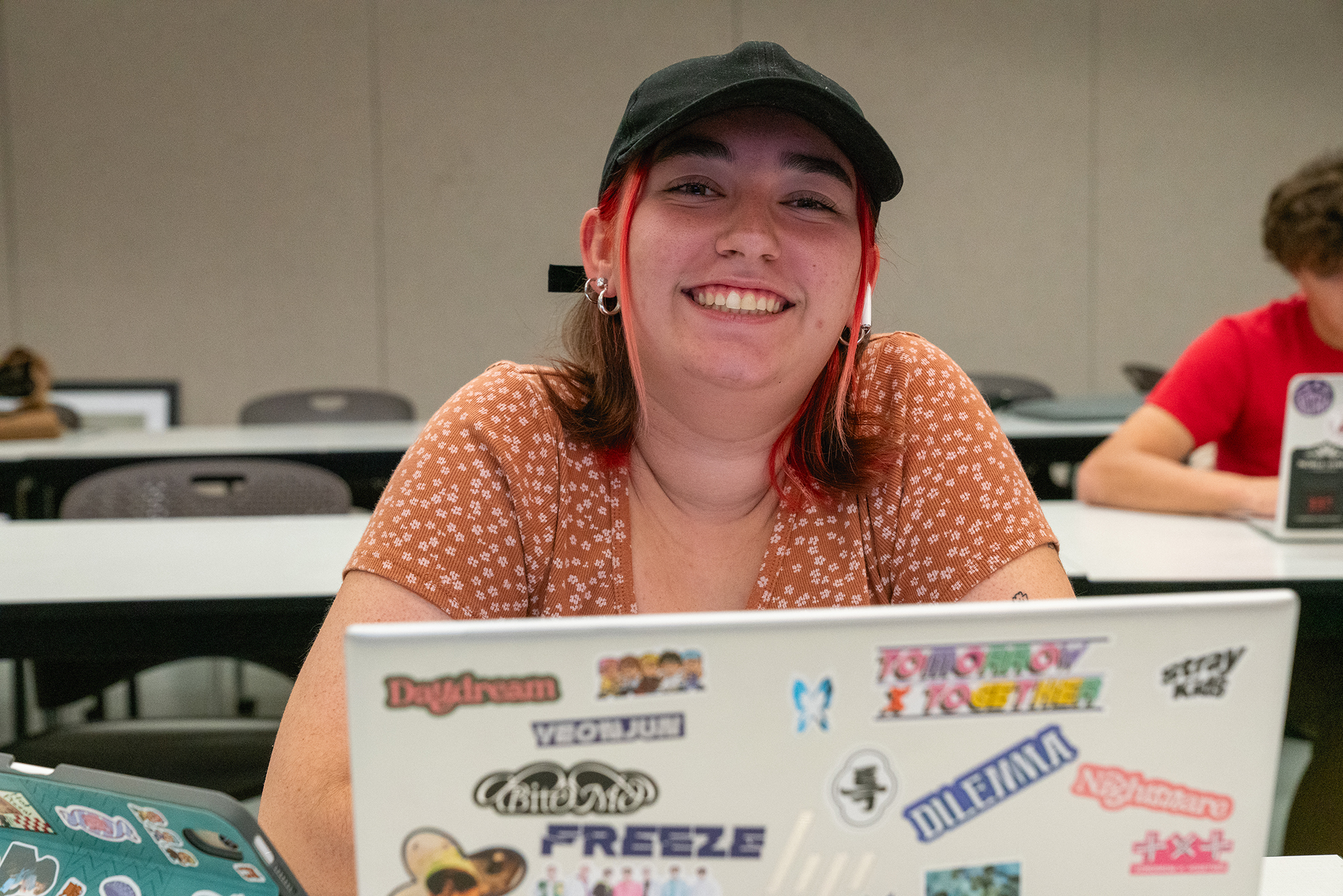 Image of girl looking over laptop and smiling at camera