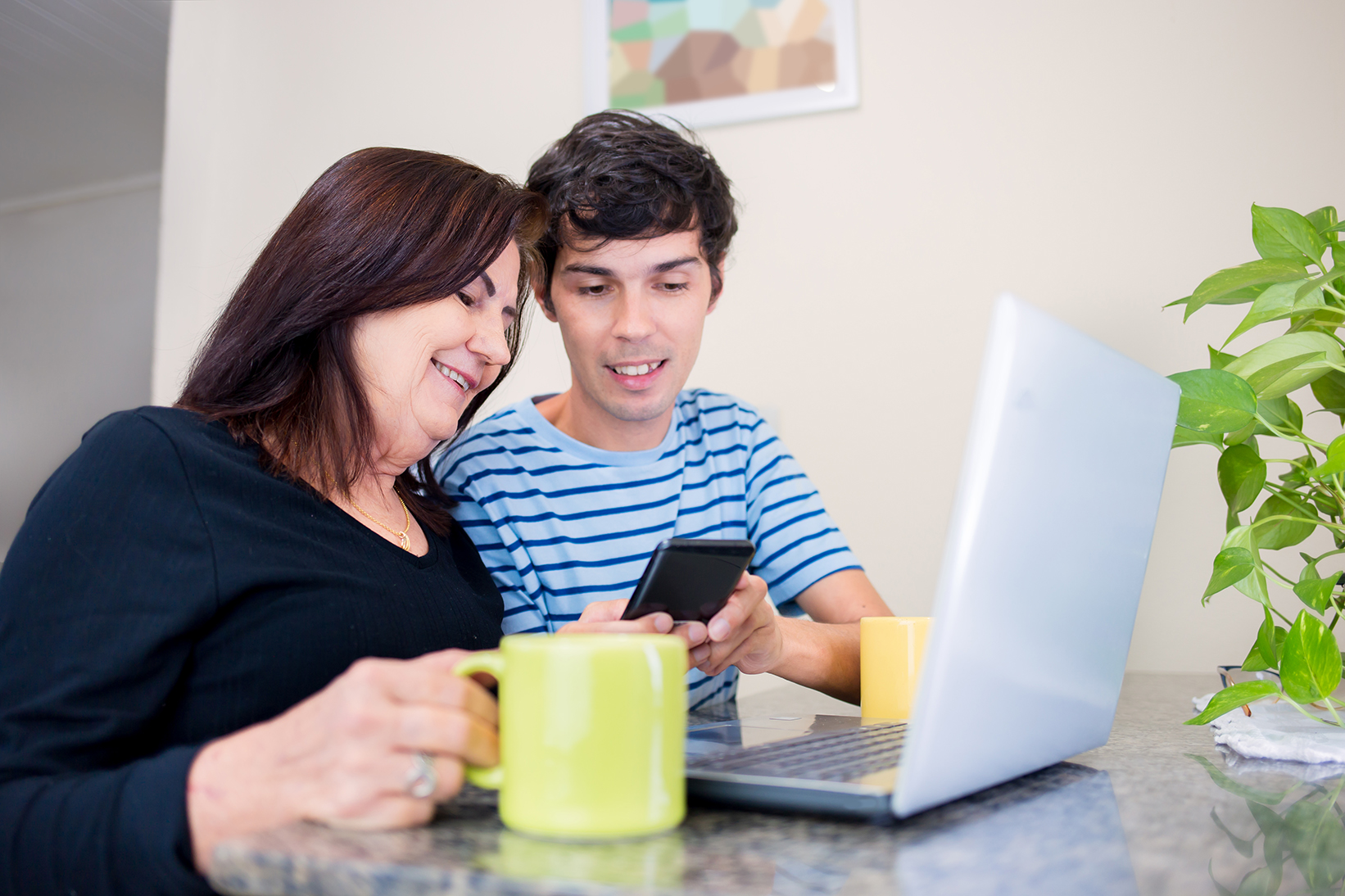 Image of mother working with student at laptop
