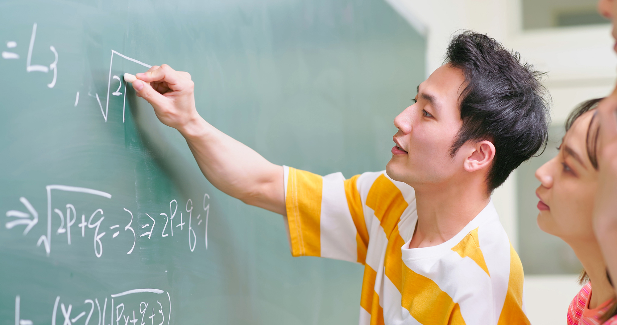 Image of student working math problems on a chalkboard