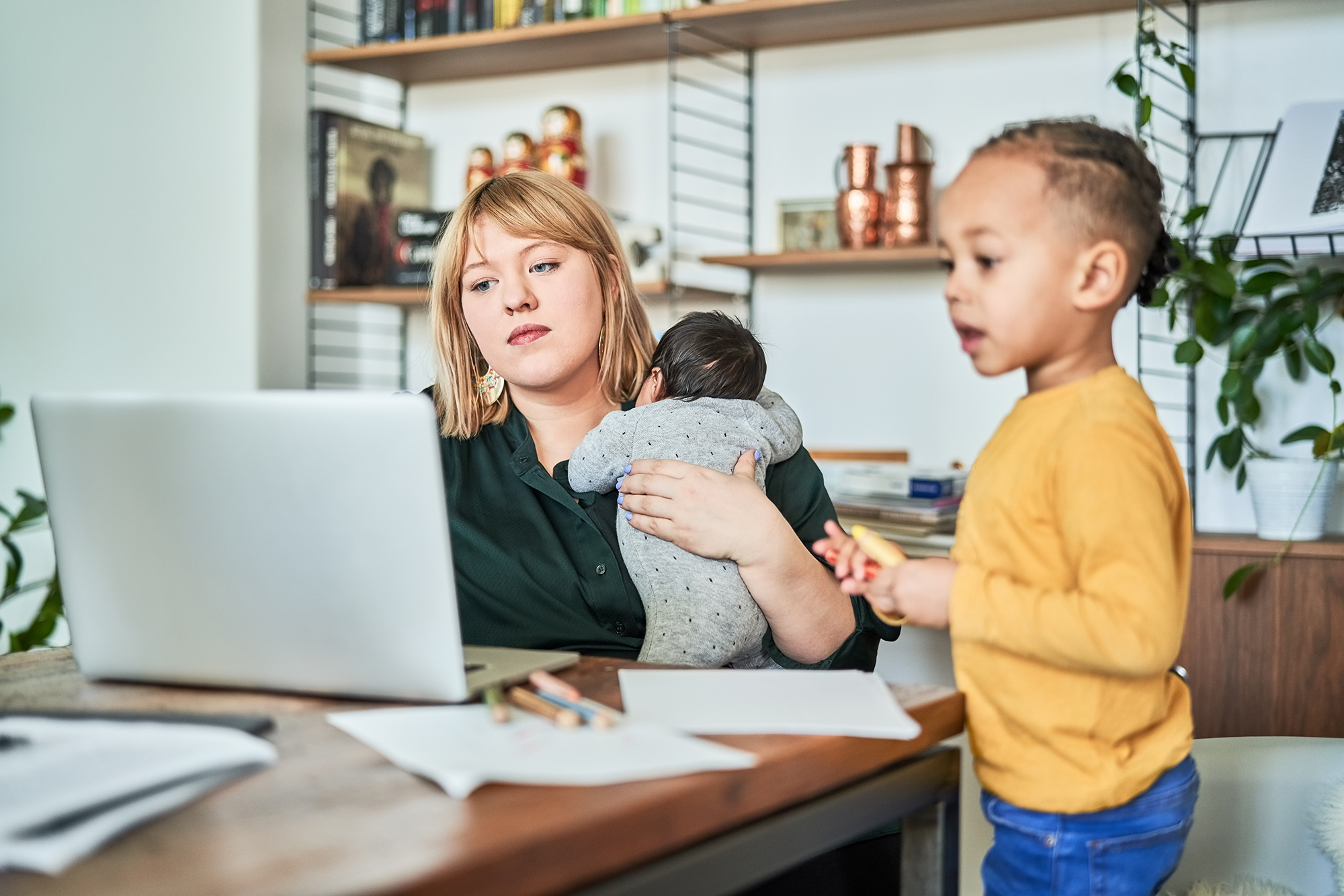 Image of mother working at computer with two children at her side