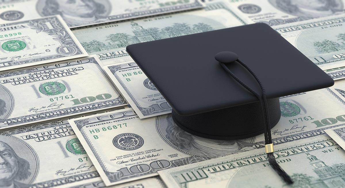 Graduation cap sitting on money.
