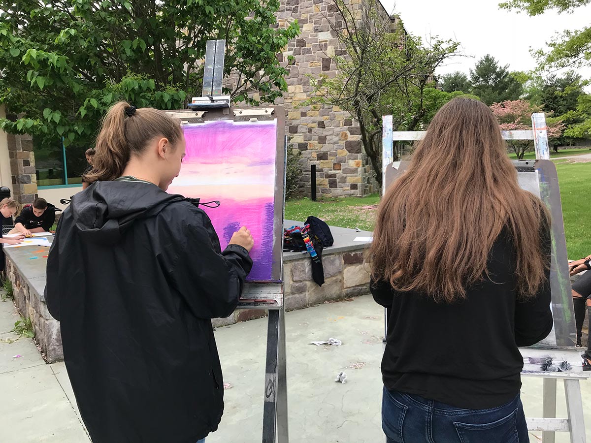 Teen artists painting at easels