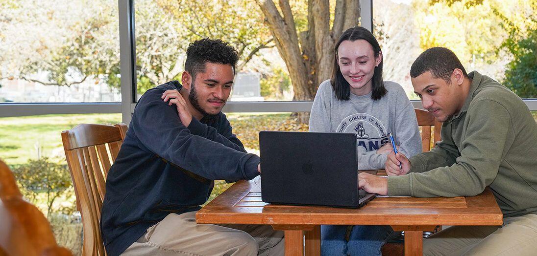 Image of 3 students looking at latptop