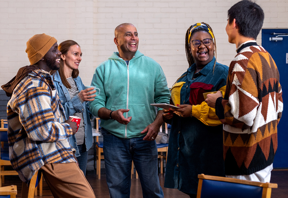 Image of a diverse group of people talking and smiling