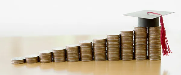 Image of a stack of coins with graduation cap on top