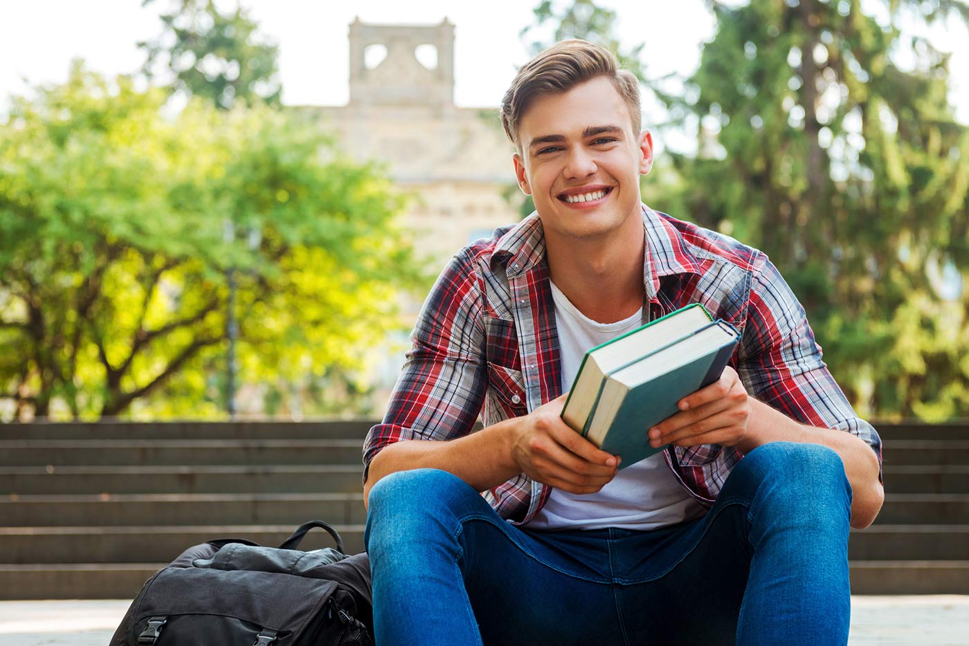 Male student sitting on steps