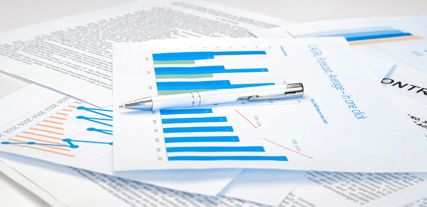 Image of papers on desk with calculations and graphs