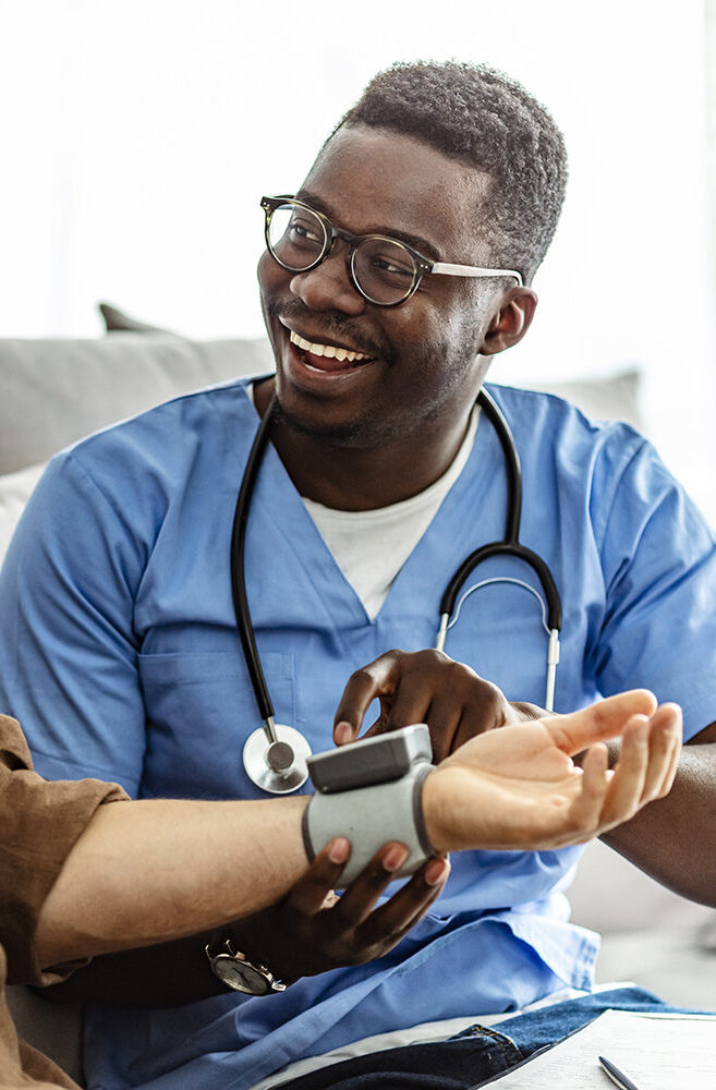 Image of a male nurse taking blood pressure of a male senior citizen