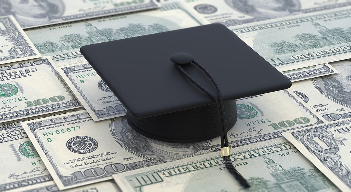 Graduation cap sitting on money.