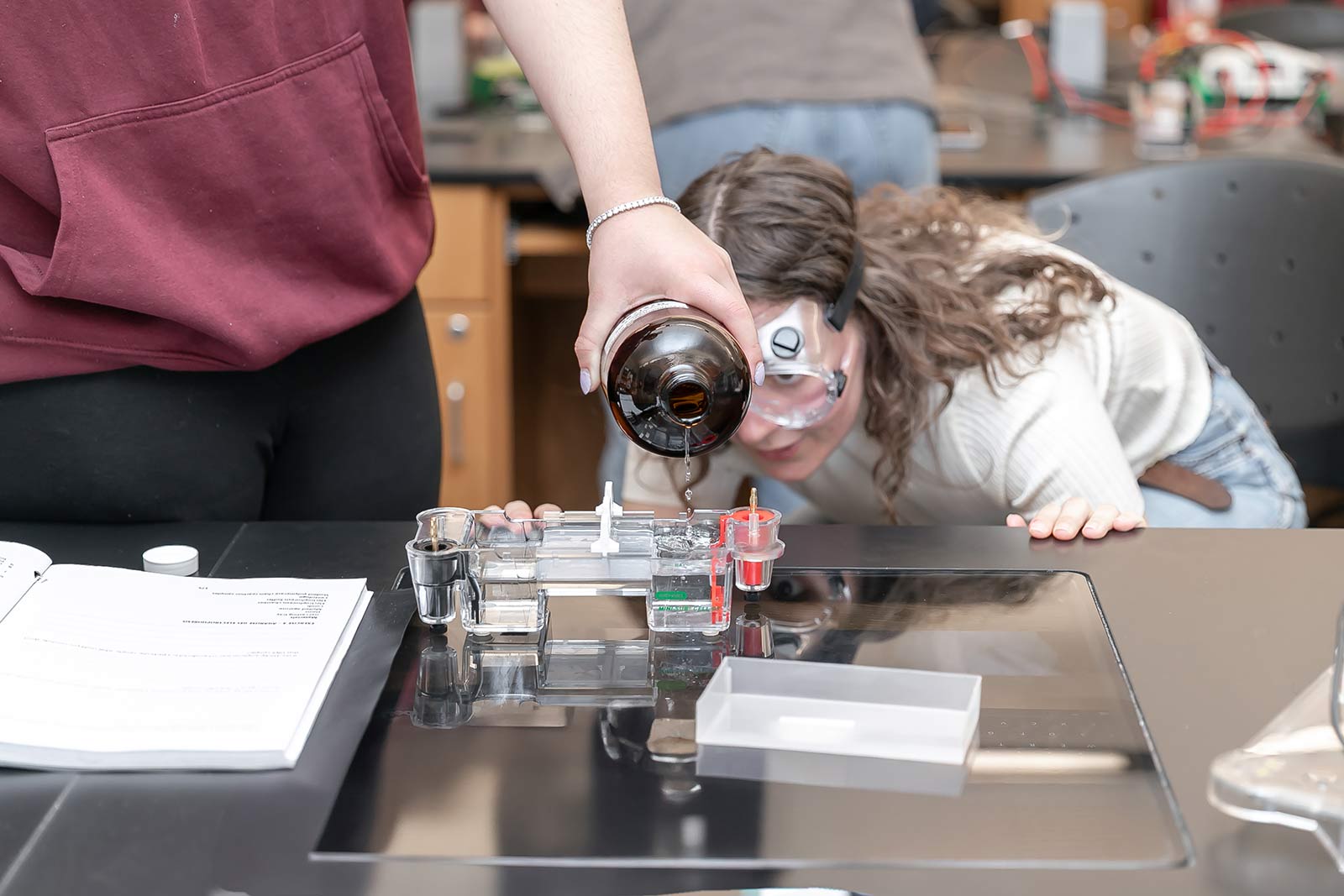 Student pouring chemicals in a chemistry lab