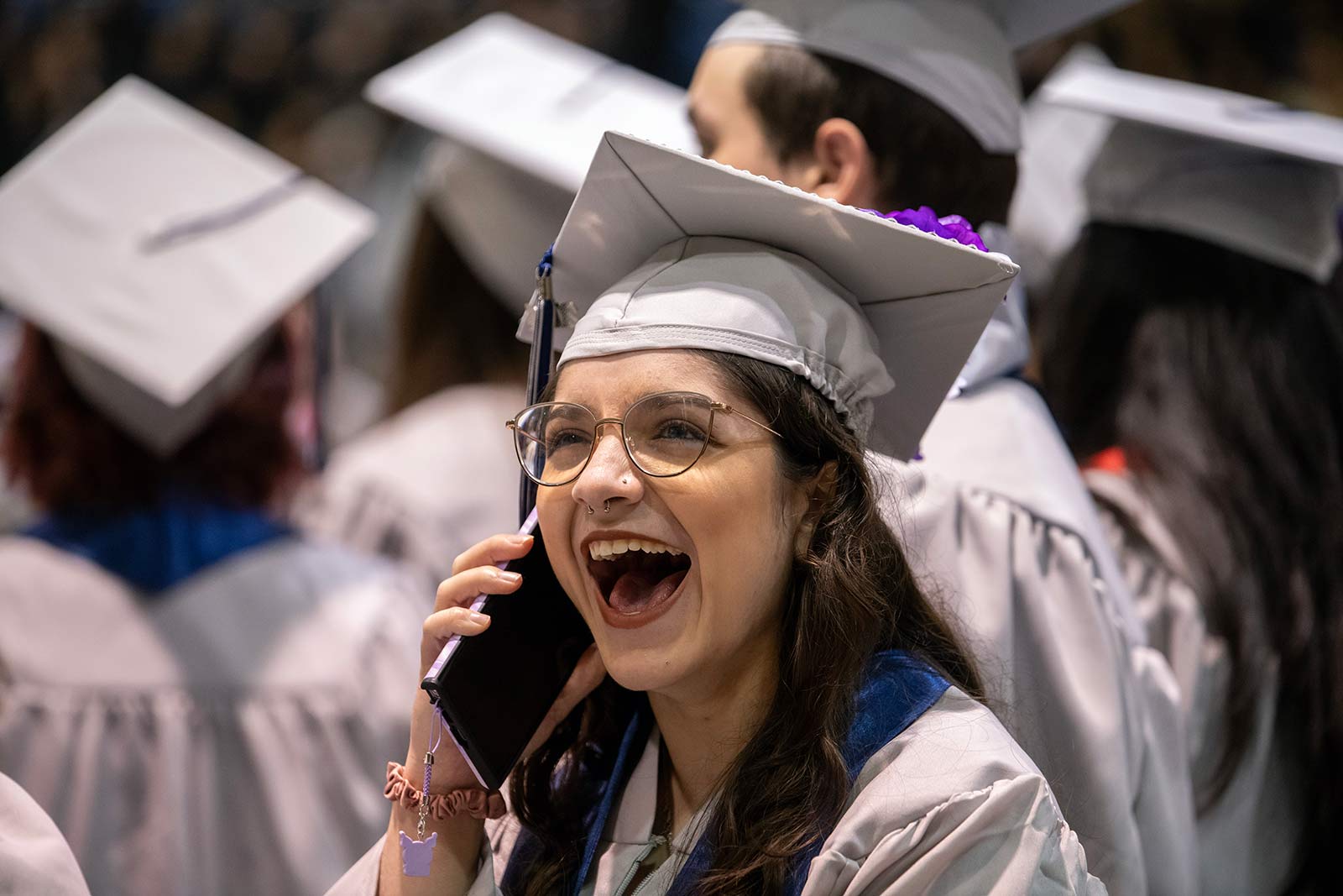 Student on phone at graduation