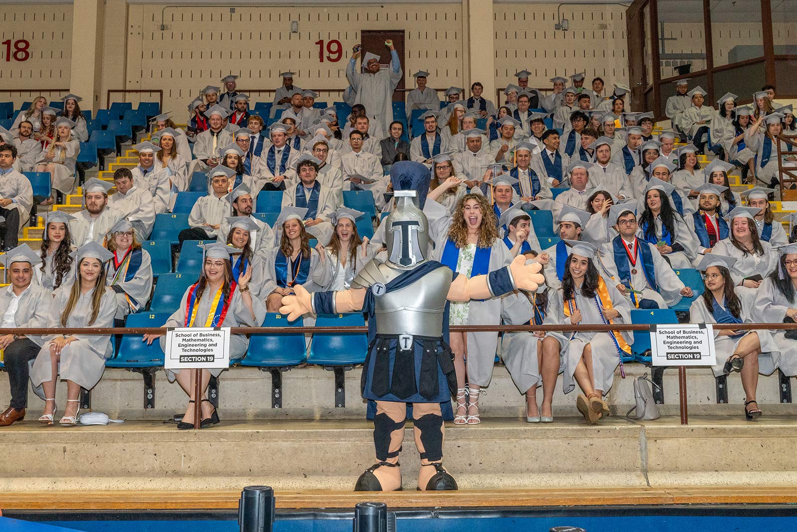 Titus the Titan in front of a cheering crowd at commencement