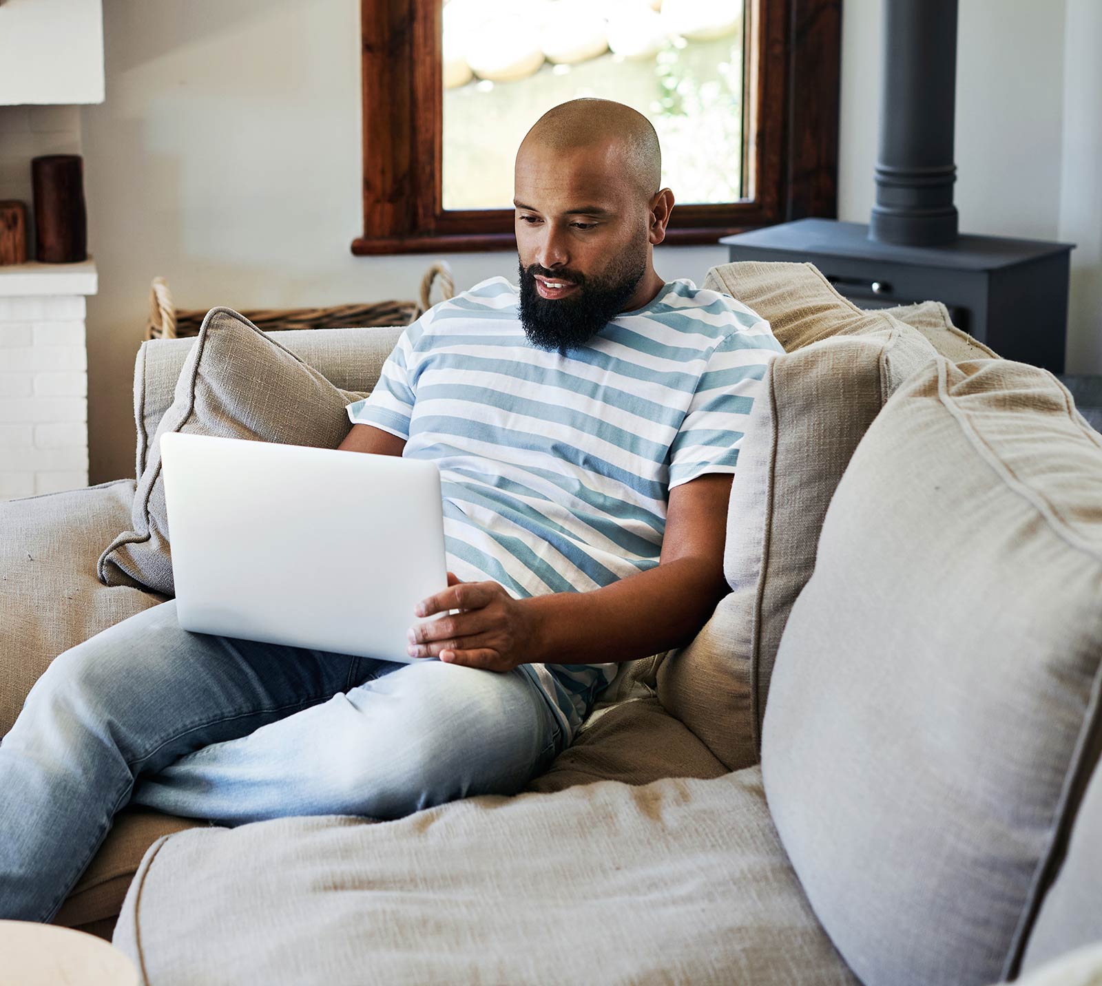 Man sitting on sofa while working on a laptop computer